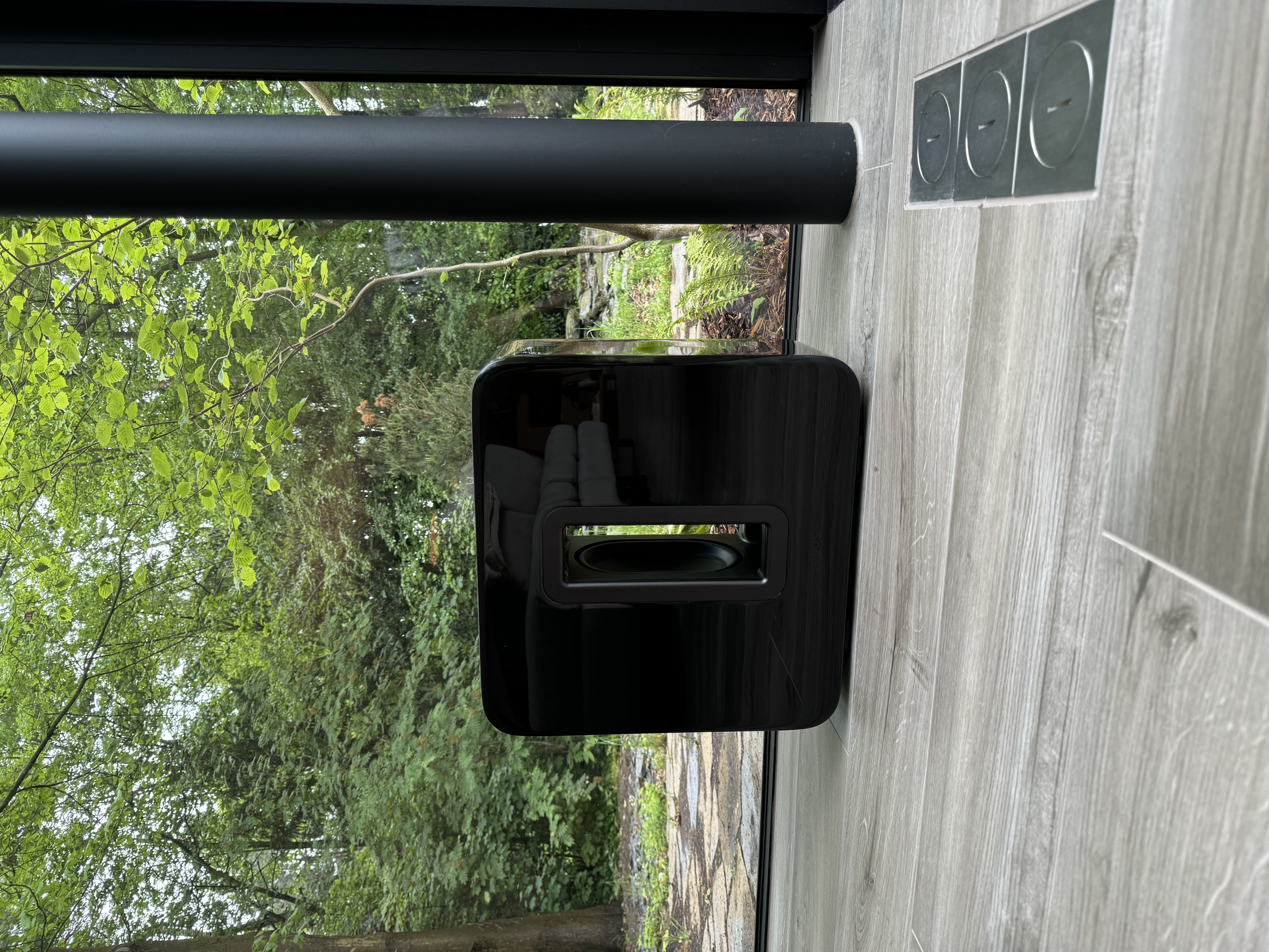 Sonos Sub opgesteld nabij de raamzijde van de woning